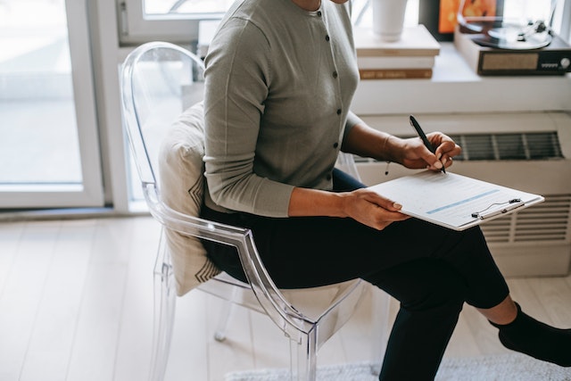 a person sitting in a chair filling out a form